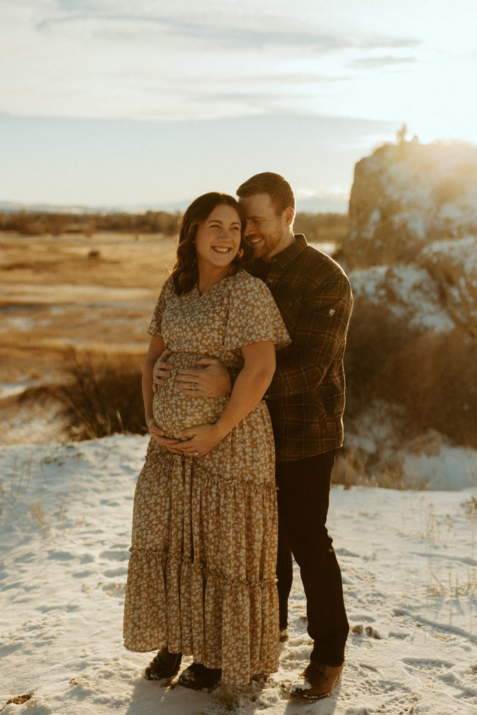 Man and woman standing in a Montana field and posing for photos