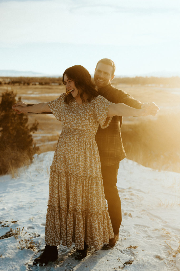 Couple having fun and posing for winter maternity photos in Montana