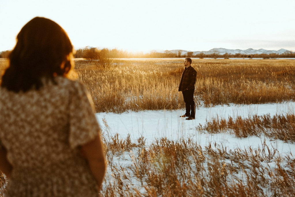Man and woman standing in a Montana field and posing for photos