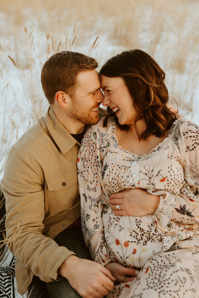 Couple posing for winter maternity photos in Montana