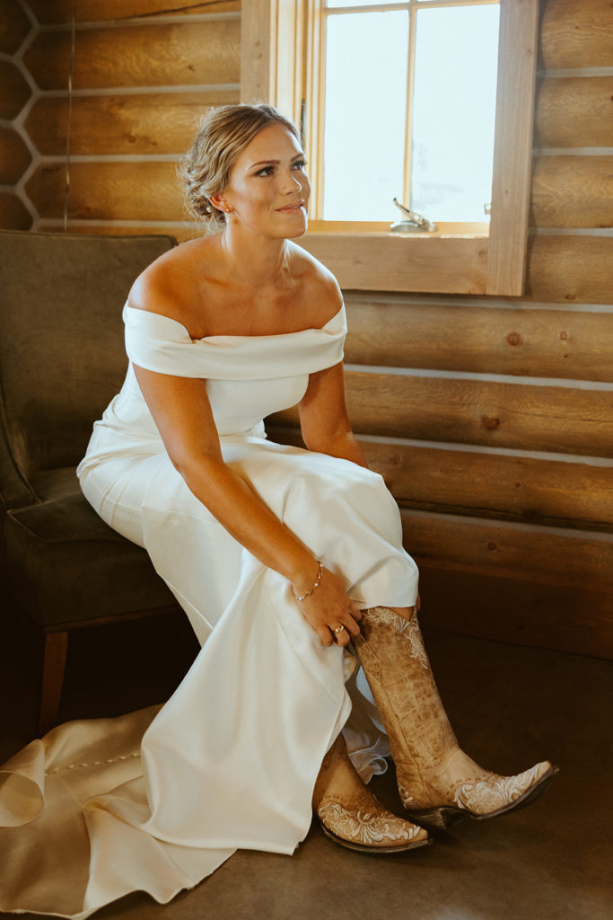 bride putting on western wedding boots