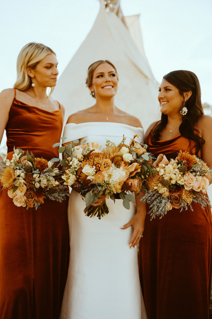 Bride and bridesmaids posing with fall wedding bouquet before montana paradise valley wedding