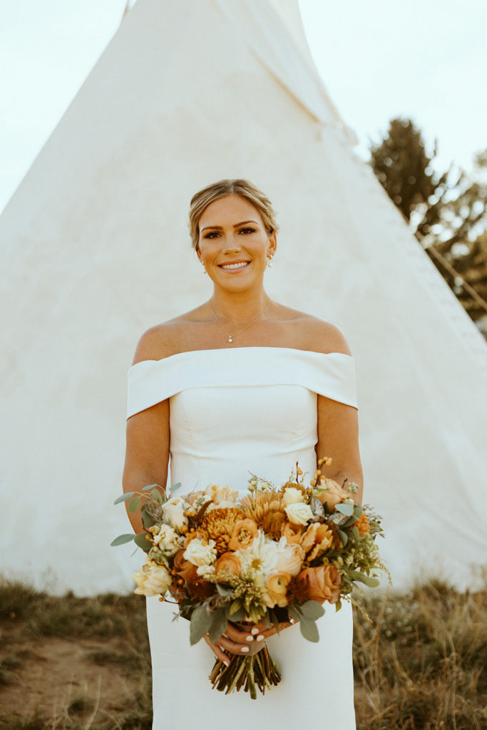 bride posing with fall wedding bouquet