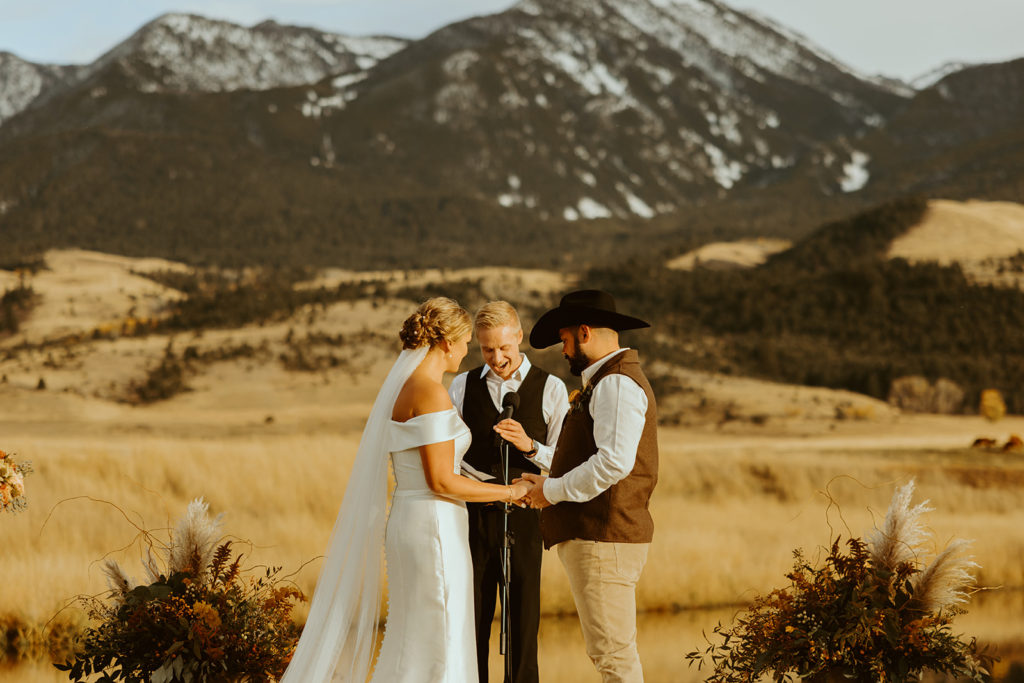 Bride and groom standing at the altar in front of montana mountains