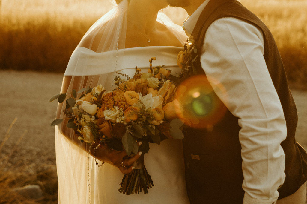 close up of bride and groom kissing during golden hour photos in montana