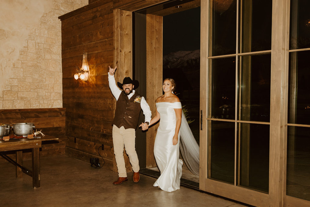 bride and groom walking into reception
