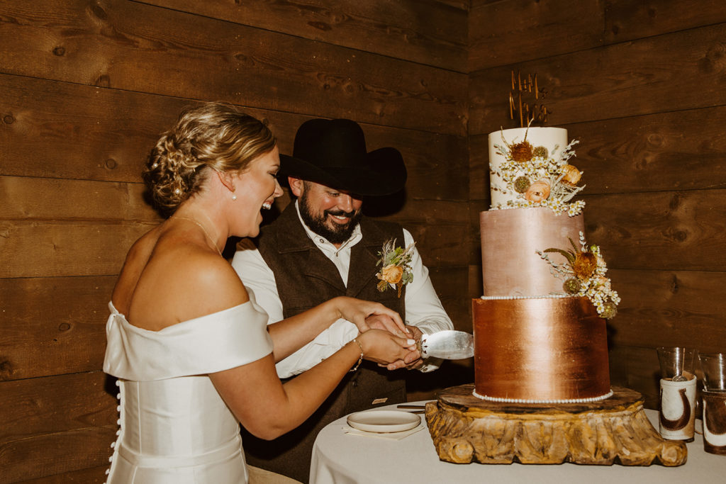 bride and groom cutting into wedding cake