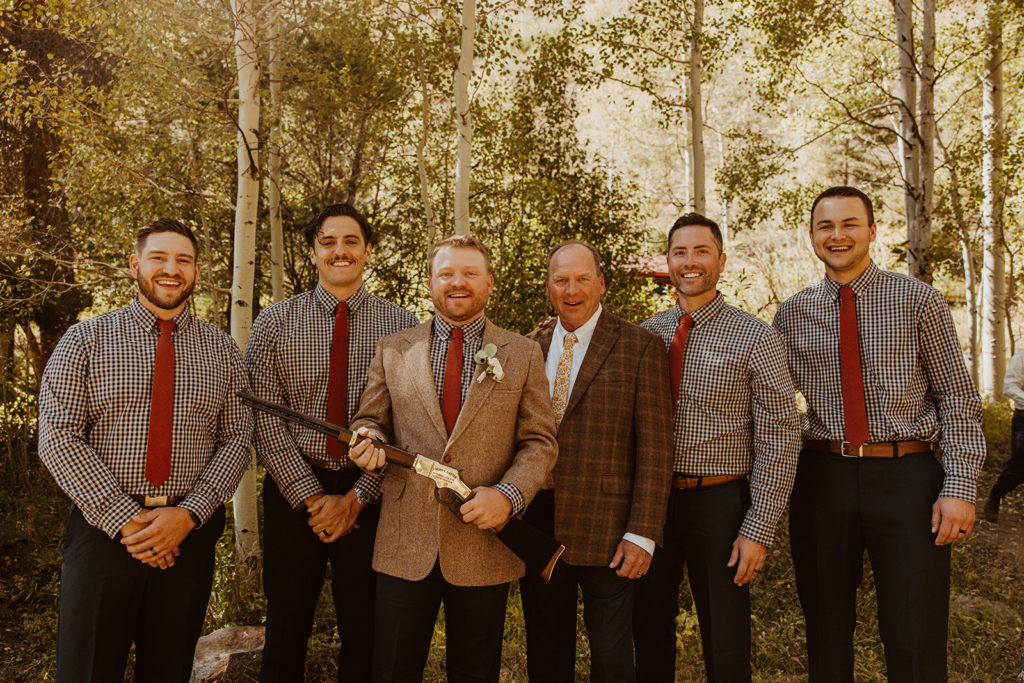 Groom posing with groosman after wedding at a ranch