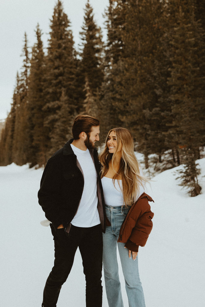 Couple posing for intimate winter engagement photos in the mountains